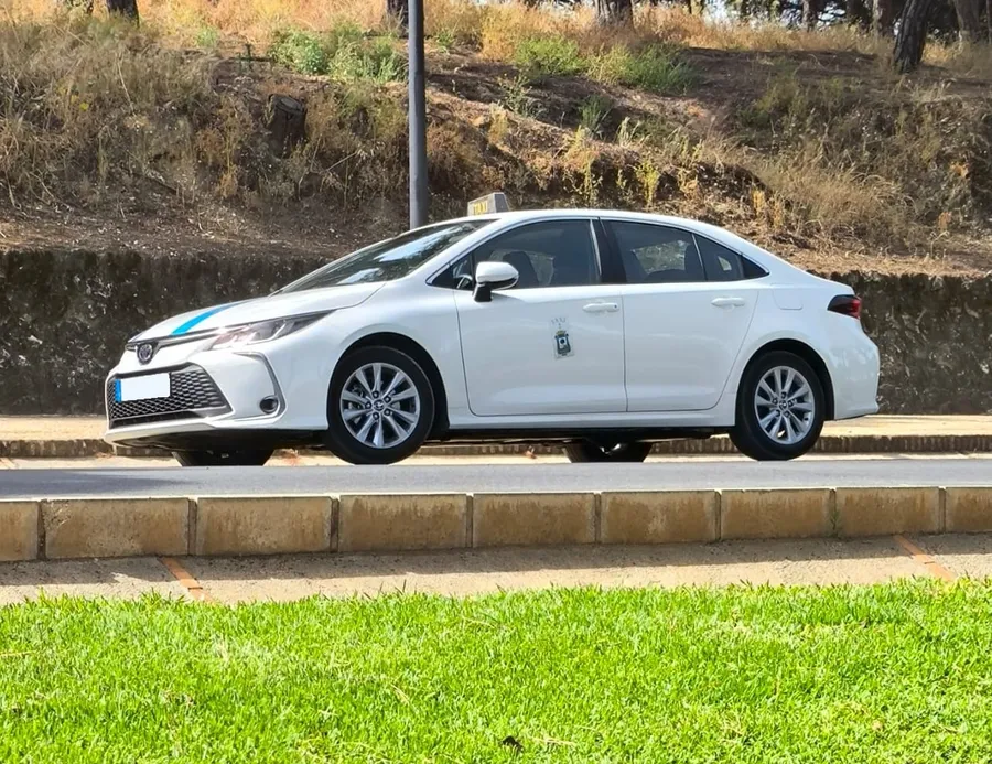 El taxi de David Toscano, un Toyota Corolla Hybrid blanco con las bandas azules y el escudo de Huelva en la puerta